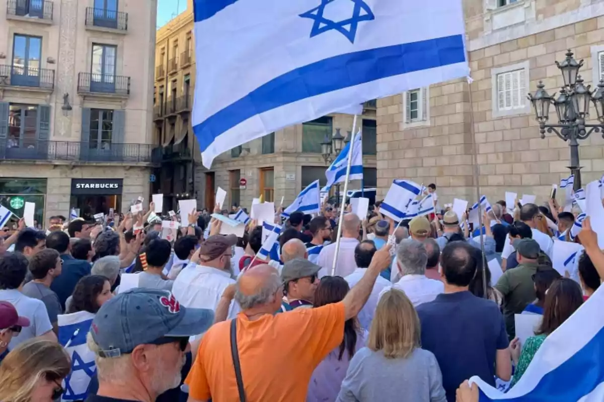 Desenes de persones, d?esquena, es manifesten amb banderes d?Israel per demanar l?alliberament dels segrestats per Hamàs