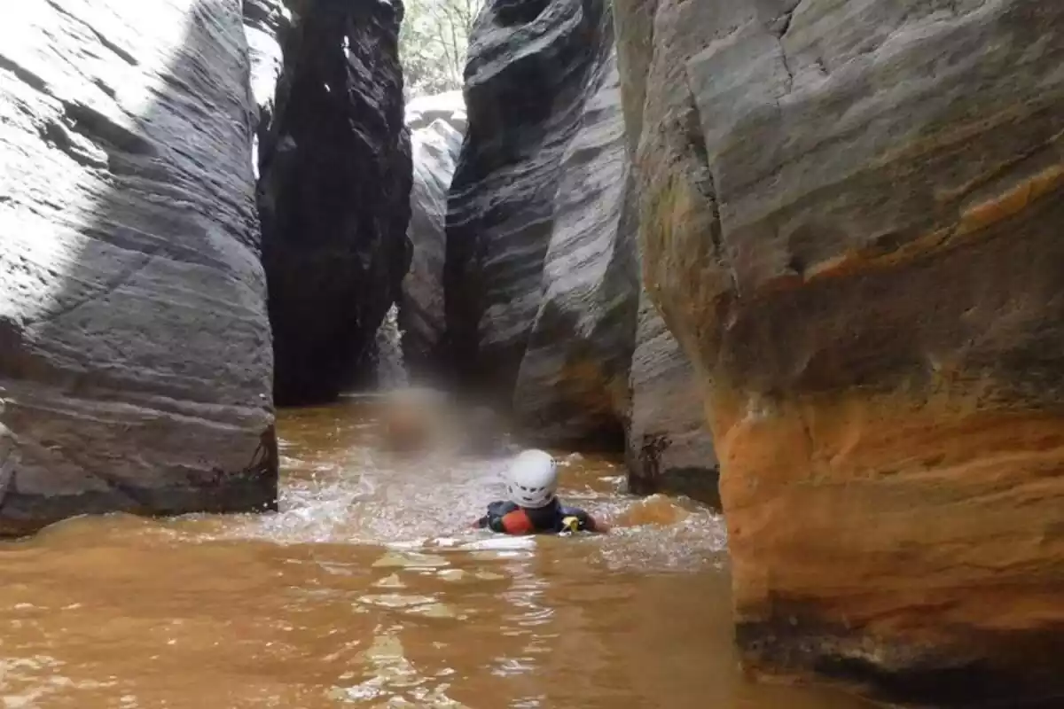 Imatge del barranc del riu Trévelez amb l'aigua marró i la gent