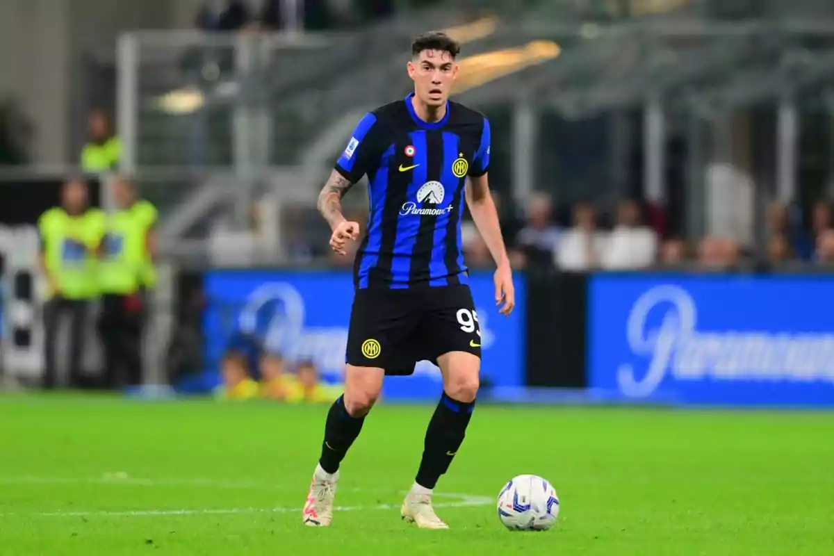 Soccer player in black and blue uniform on the playing field with a ball at his feet. Soccer player in black and blue uniform on the playing field with a ball at his feet.