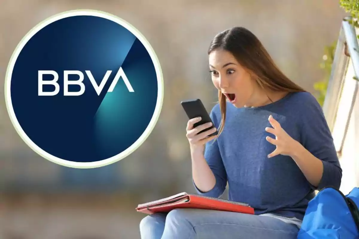 Dona sorpresa mirant el telèfon mòbil al costat del logo de BBVA.