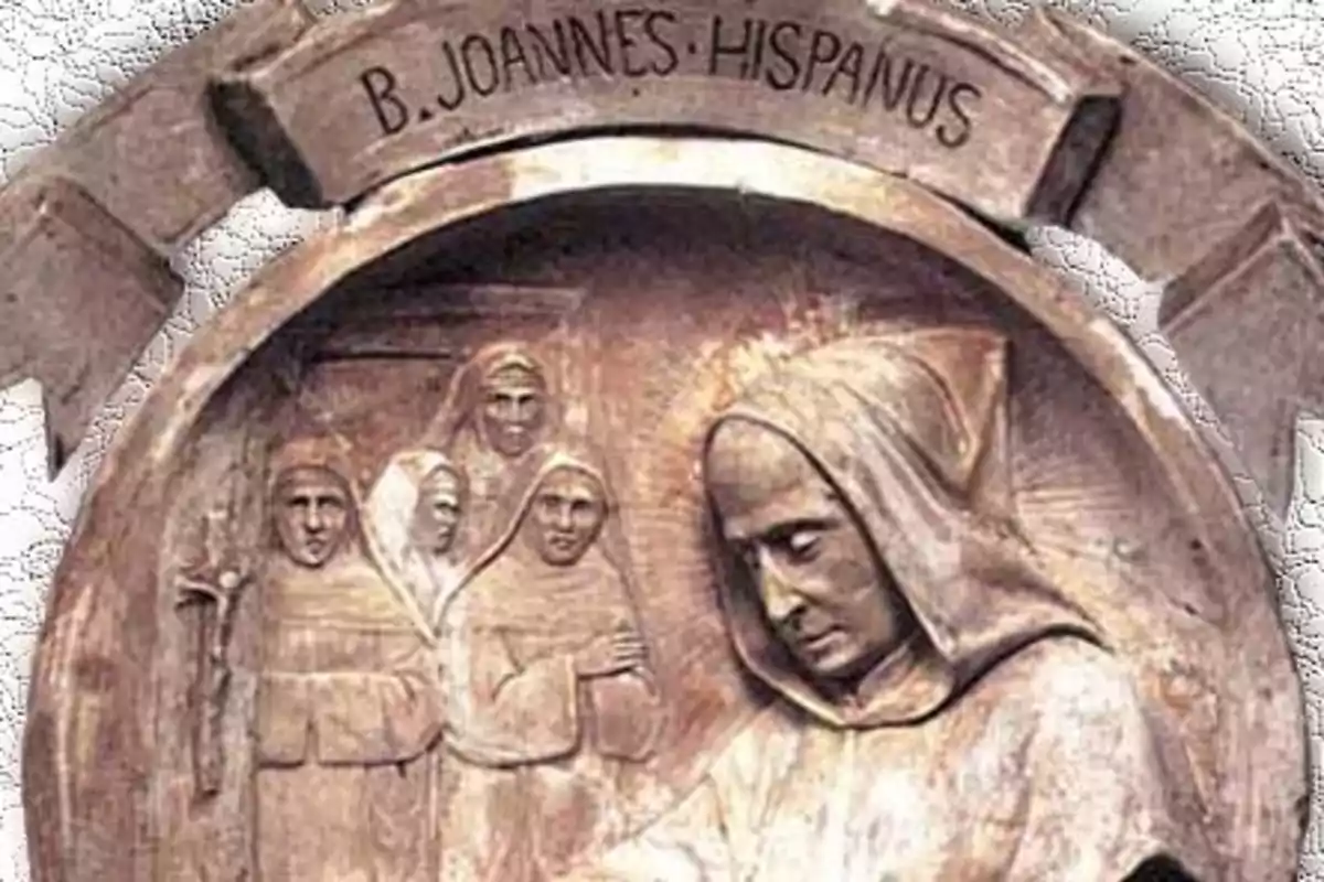 Relleu d’un monjo amb caputxa envoltat d’altres monjos i la inscripció B Joannes Hispanus a la part superior Relleu d’un monjo amb caputxa envoltat d’altres monjos i la inscripció B Joannes Hispanus a la part superior