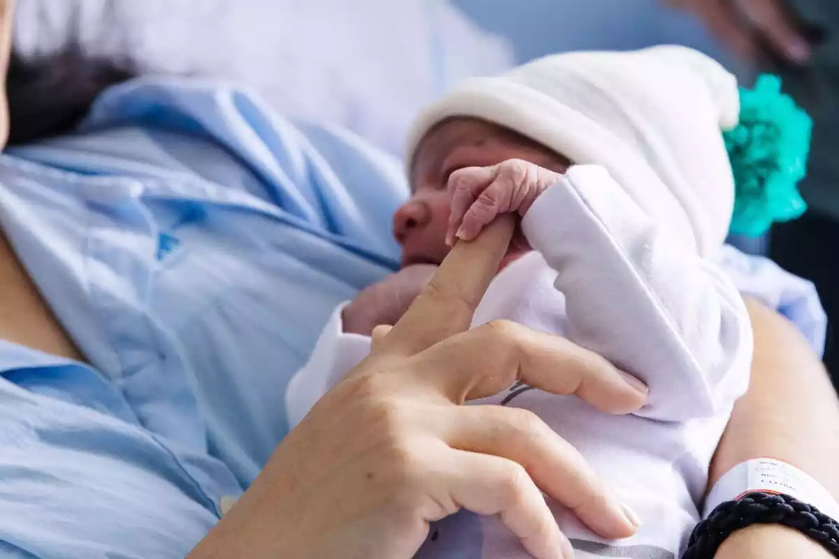 María Liz dóna un dit al seu fill Erik, que ha estat el primer nadó nascut el 2024 a Madrid, a l'Hospital Universitari La Paz, l'1 de gener del 2024, a Madrid (Espanya)