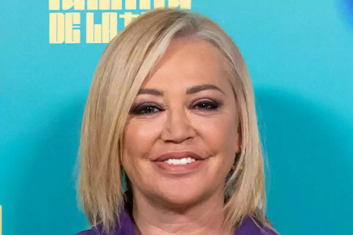 Belén Esteban amb cabell ros i somriure davant d'un fons blau en la presentació de La Família de la Tele.