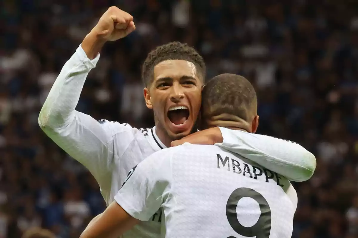 Dos jugadors de futbol celebrant un gol a un estadi