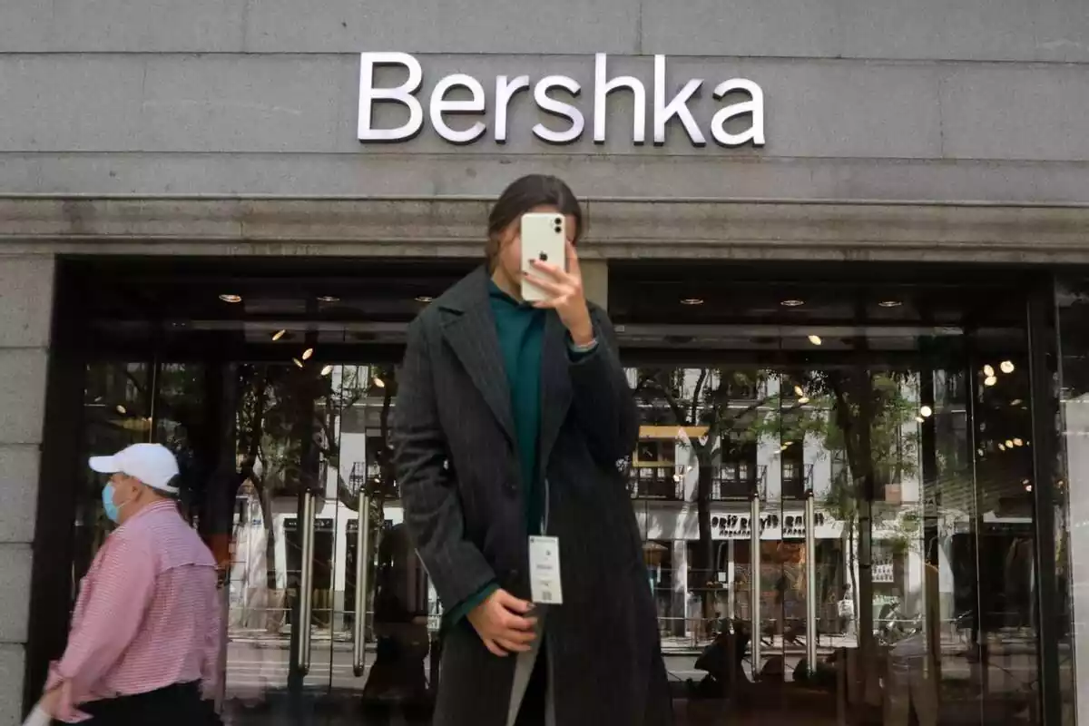 Botiga Bershka i primer pla de l'abric llarg ratlles