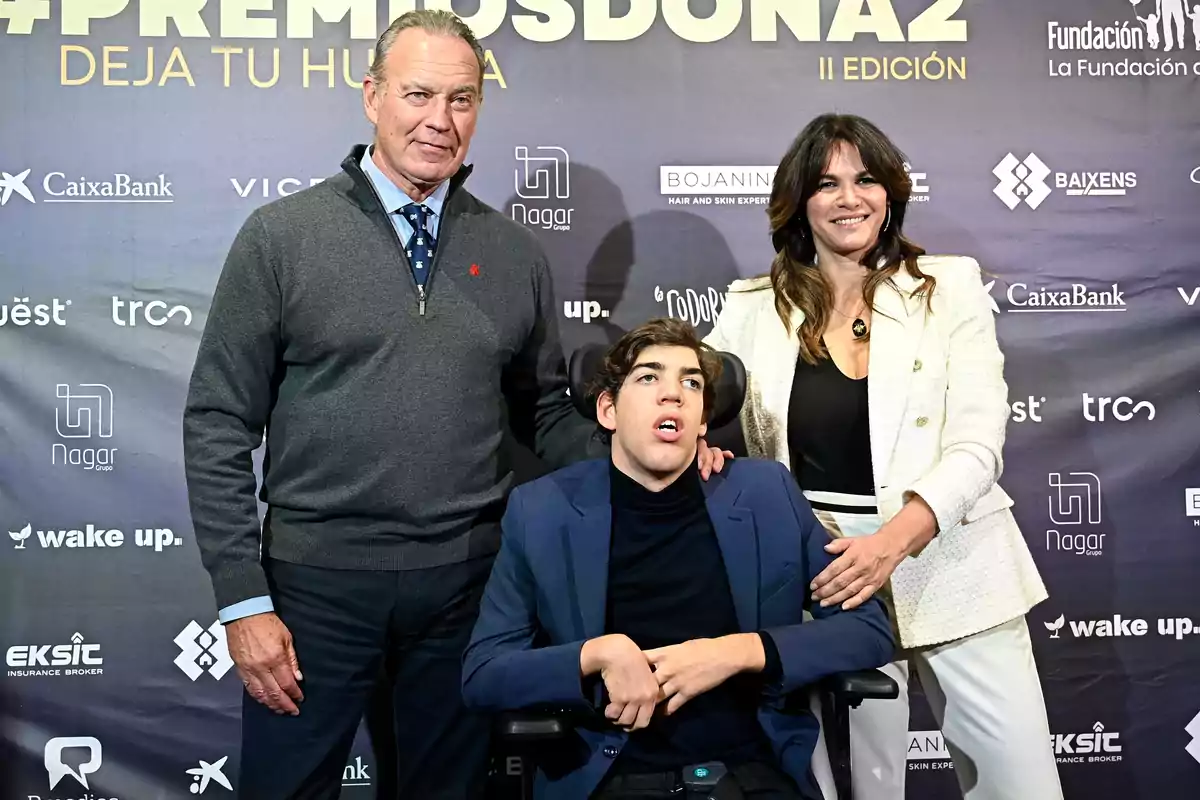 Bertín Osborne, Kike Osborne and Fabiola Martínez pose together at an event with a background of sponsor logos.