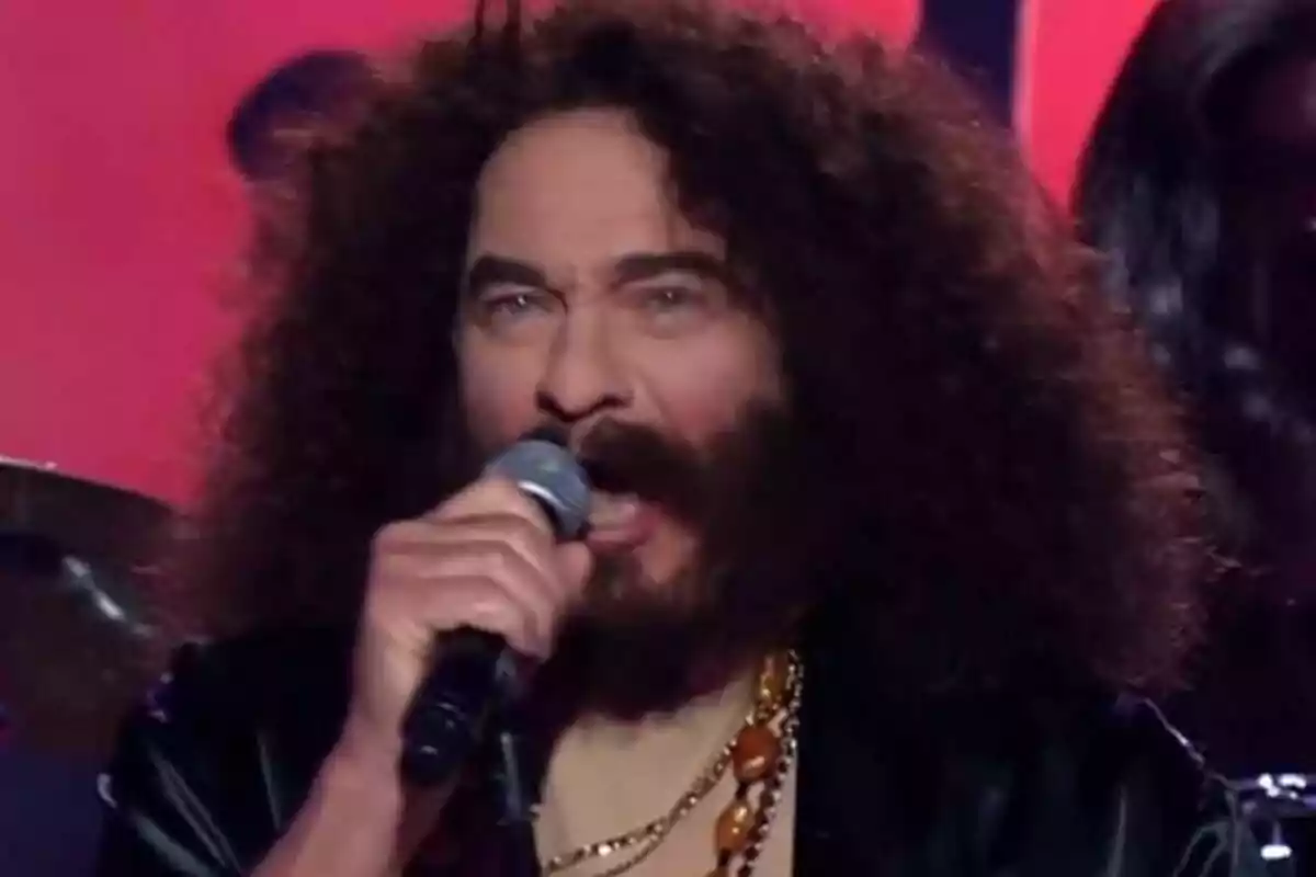 Bertín Osborne amb cabell arrissat i barba cantant en un escenari de Tu Cara Me Suena mentre sosté un micròfon