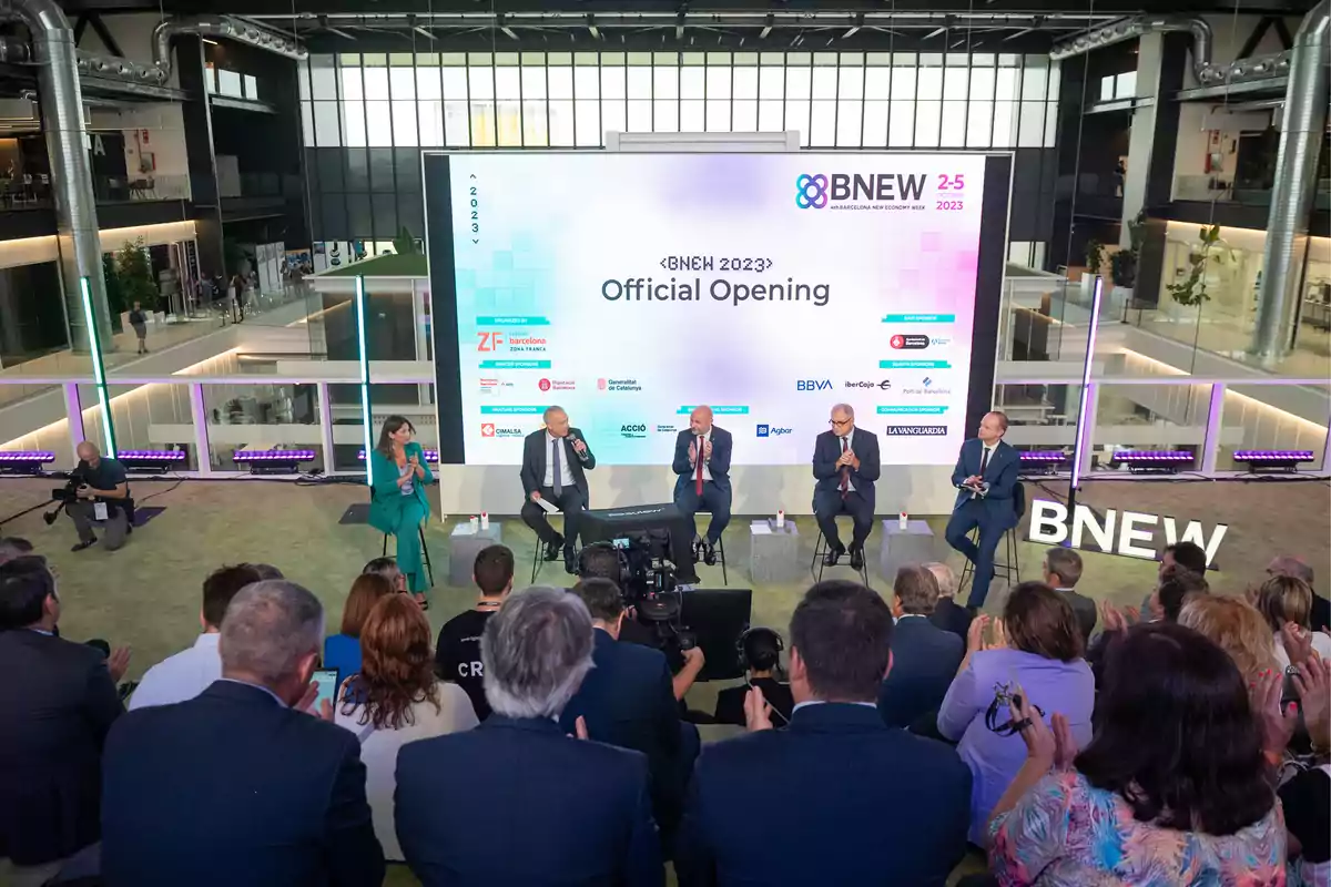 Evento de apertura oficial de BNEW 2023 con panelistas y audiencia en un espacio moderno y bien iluminado.