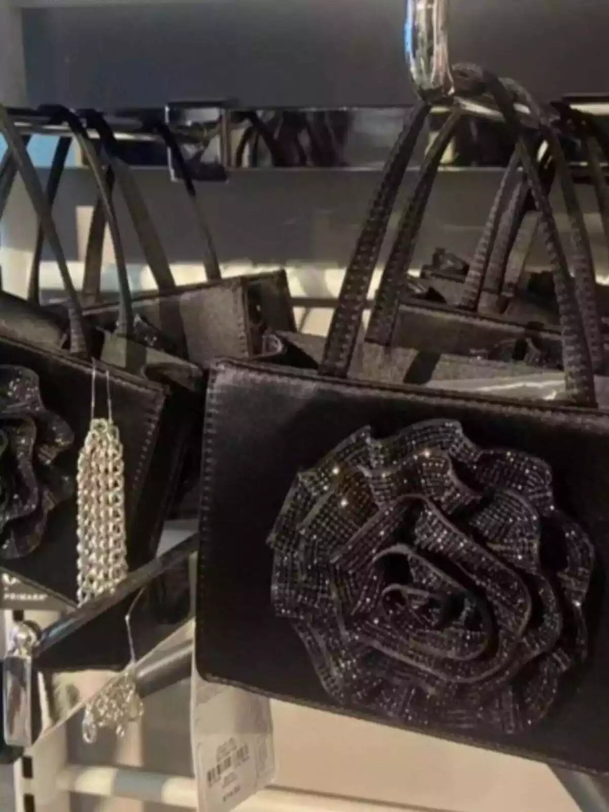 Bossa negra de Primark amb una flor gran brillant Bossa negra de Primark amb una flor gran brillant