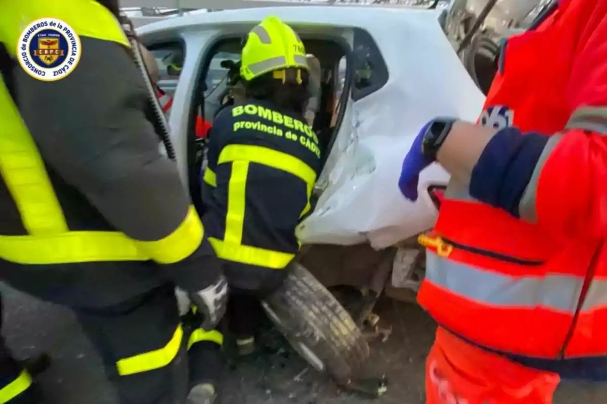 Bombers i personal d'emergència treballen per rescatar una persona atrapada en un vehicle després d'un accident.