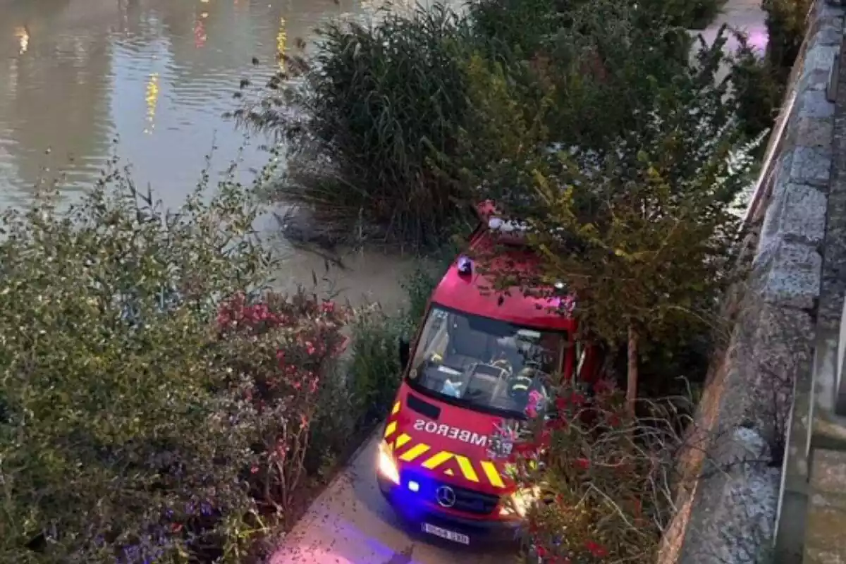 Camió de bombers al costat d'un riu