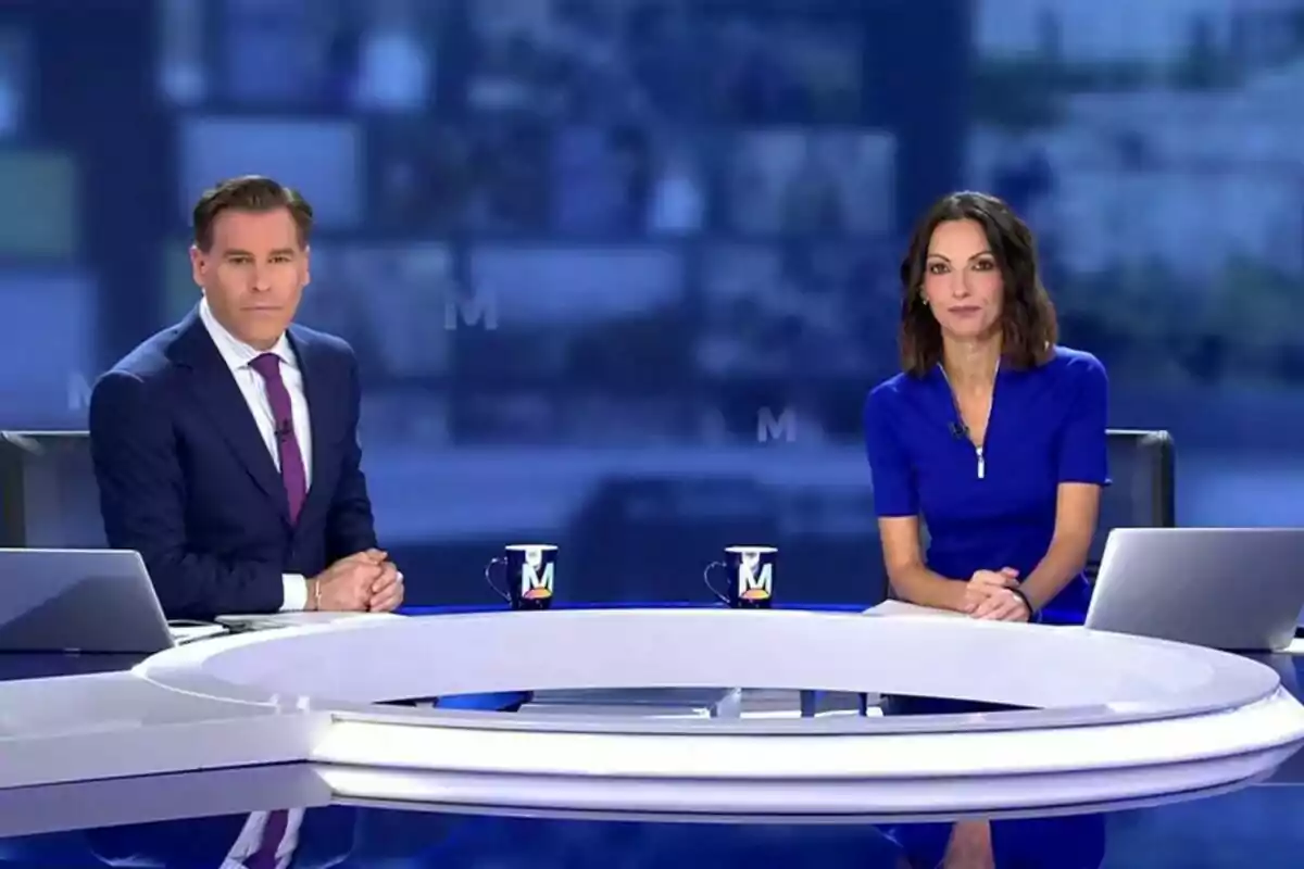 Bricio Segòvia i Laila Jiménez asseguts al plató d'Informativos telecinco amb una taula blanca i tasses de cafè davant seu.