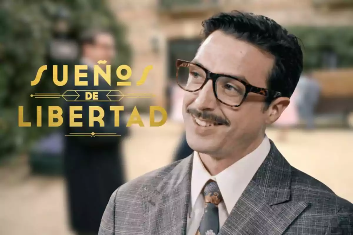Bruno Tamarit amb ulleres i bigoti somriu mentre porta vestit i corbata, al costat del text Sueños de Libertad en lletres daurades