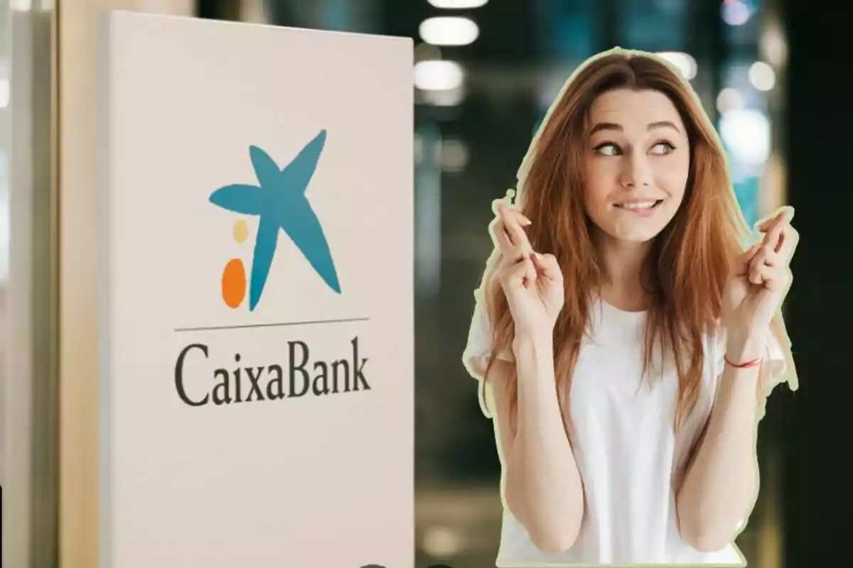 Una mujer con los dedos cruzados frente a un cartel de CaixaBank.