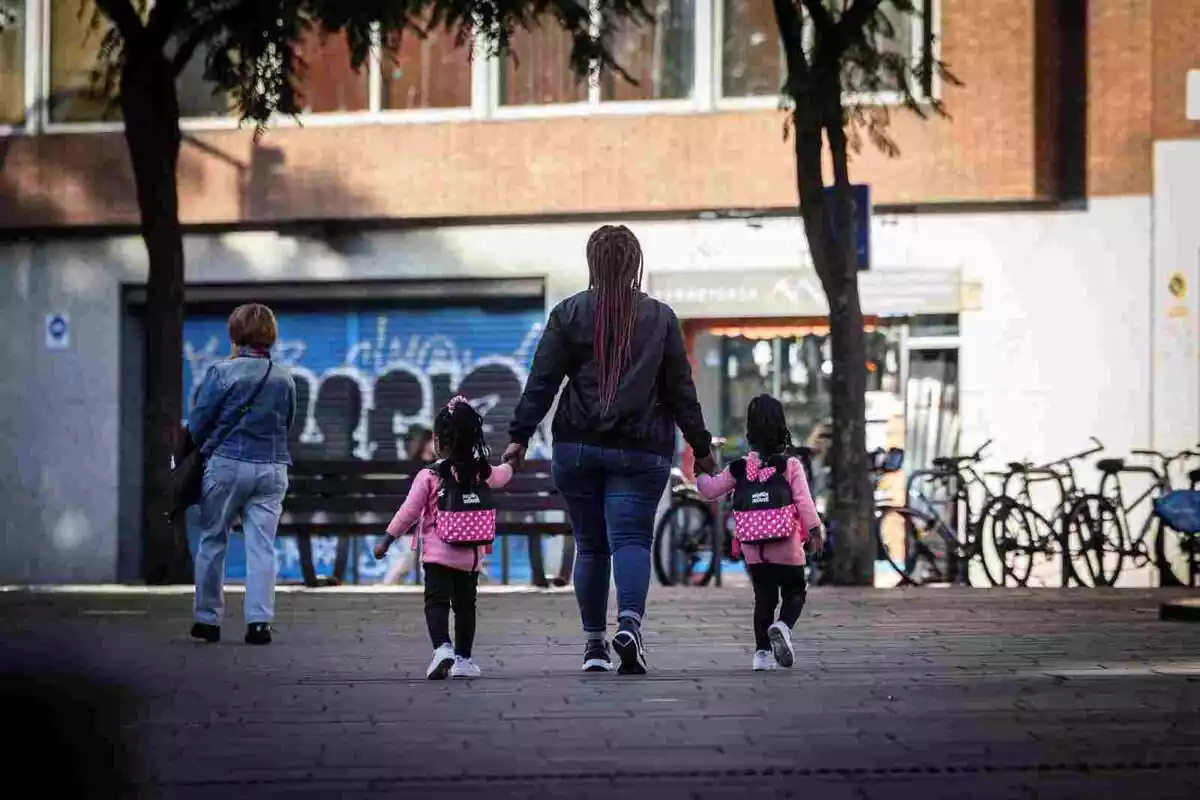 Imatge d´una mare caminant amb dues nenes a Barcelona