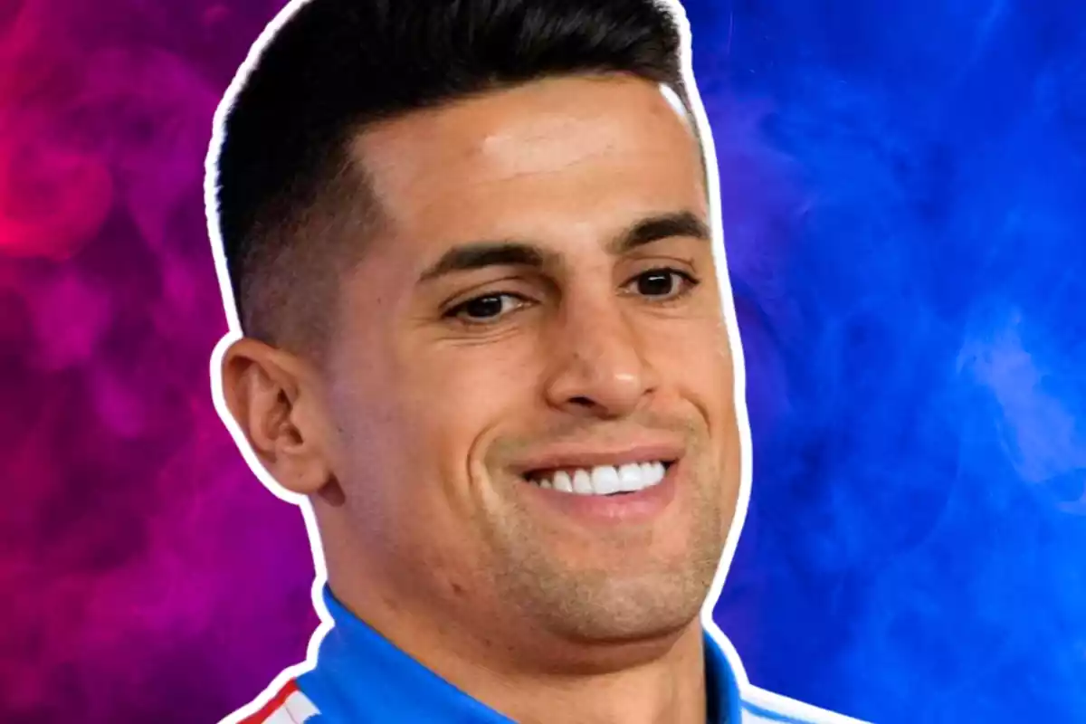 Joao Cancelo amb un gran somriure davant un fons de color blau i morat