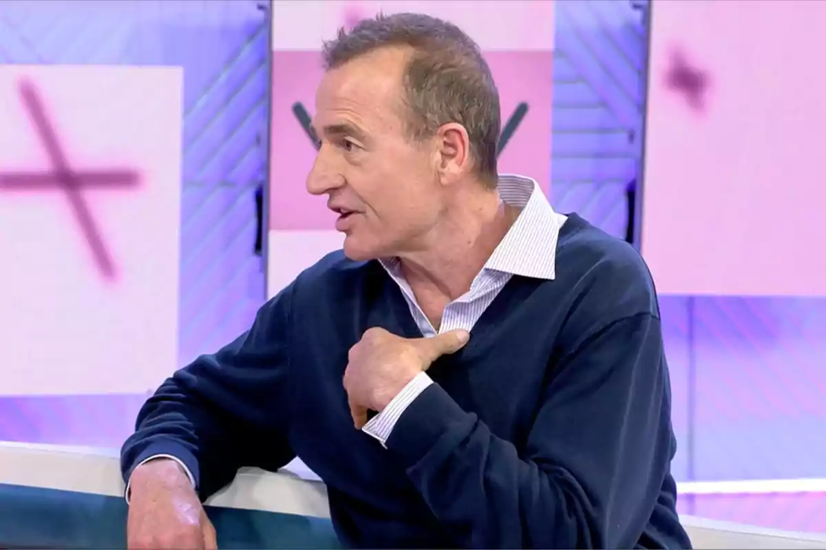 Alessandro Lequio de perfil amb jersei blau i camisa blanca parla gesticulant a 'Vamos a ver' amb fons de colors clars. Alessandro Lequio de perfil amb jersei blau i camisa blanca parla gesticulant a 'Vamos a ver' amb fons de colors clars.
