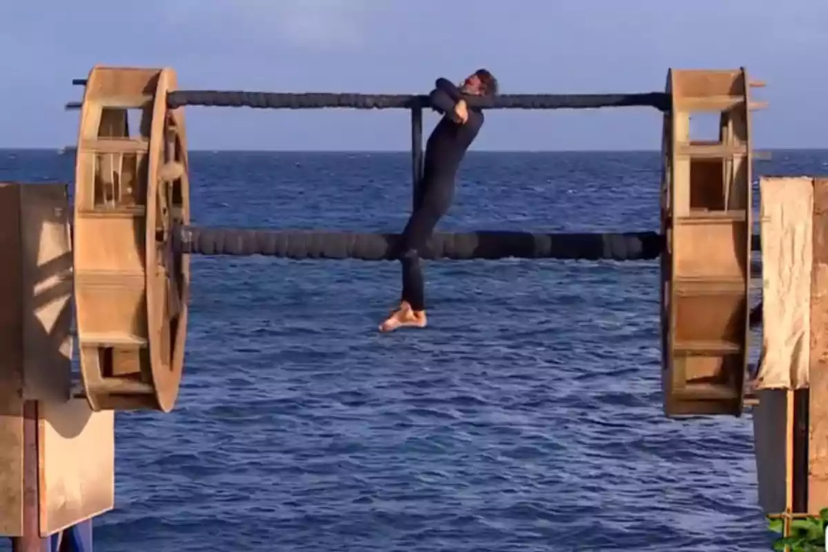 Álvaro Muñoz Escassi penjant d’una estructura de barres sobre el mar en un desafiament de resistència física Álvaro Muñoz Escassi penjant d’una estructura de barres sobre el mar en un desafiament de resistència física