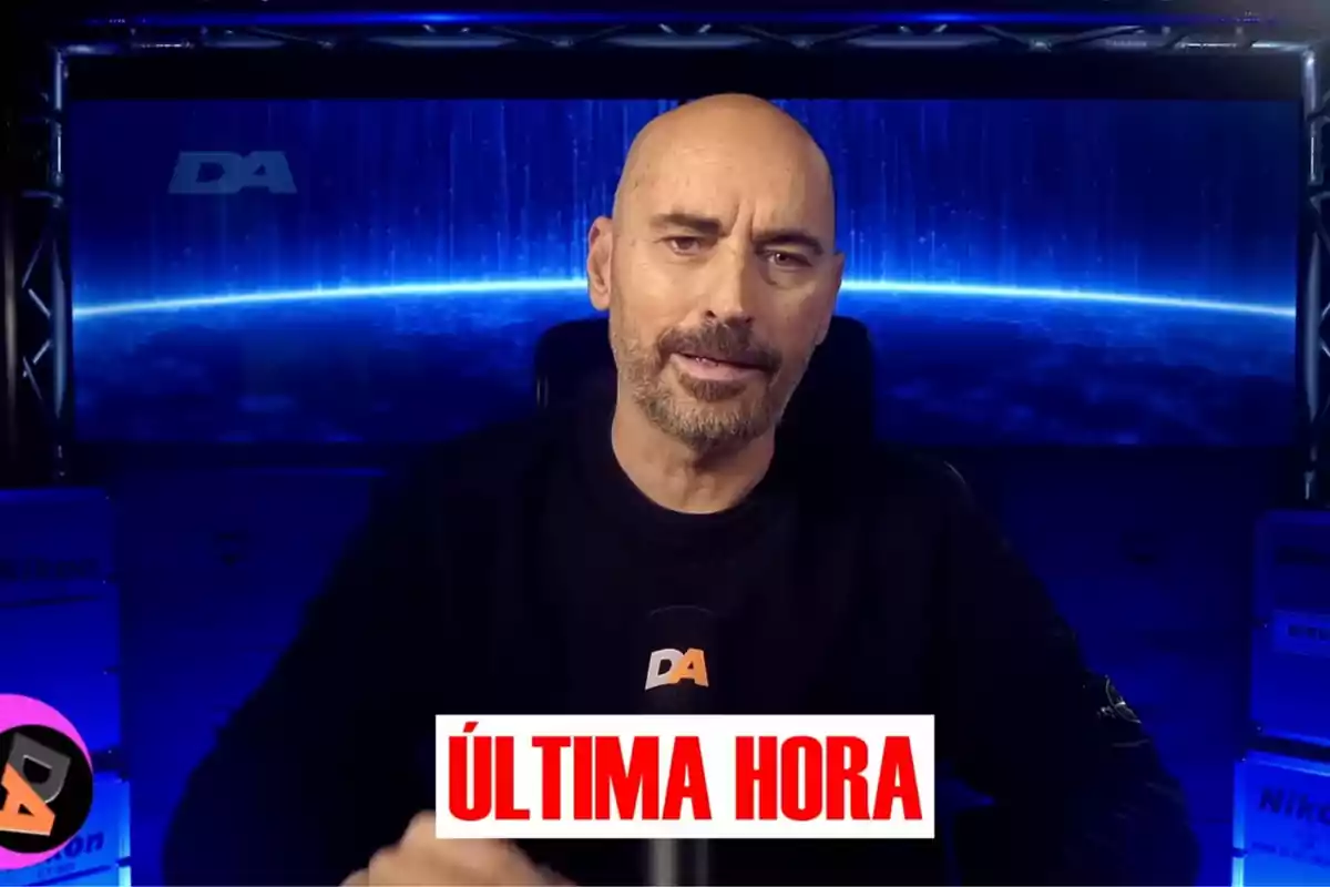 Diego Arrabal amb barba està parlant davant d'un micròfon amb el logotip Diego Arrabal amb barba està parlant davant d'un micròfon amb el logotip