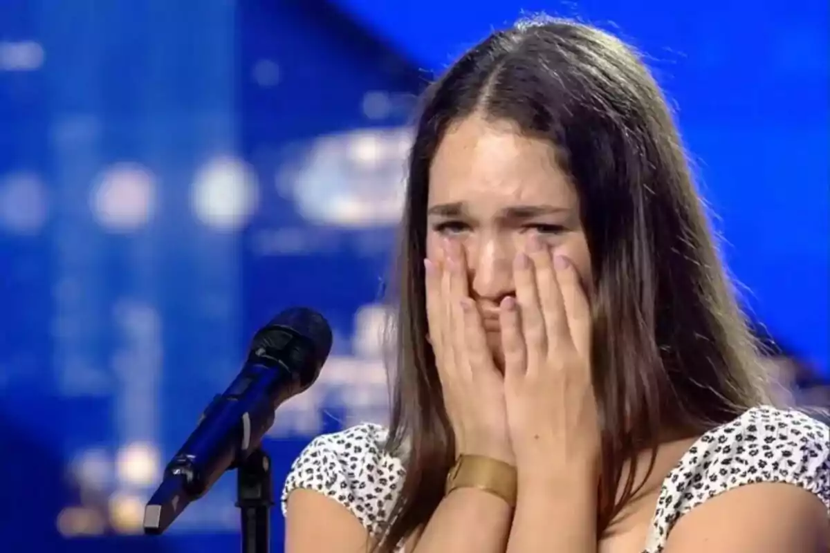 Una jove anomenada Carla emocionada amb les mans a la cara davant d'un micròfon a l'escenari de Got Talent.