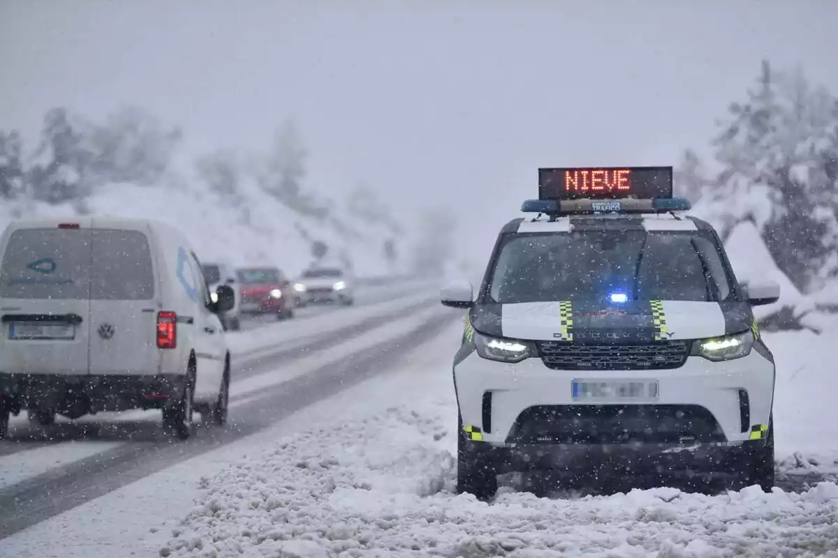 Un cotxe de la Guàrdia Civil sobre la neu indicant que la carretera està tancada