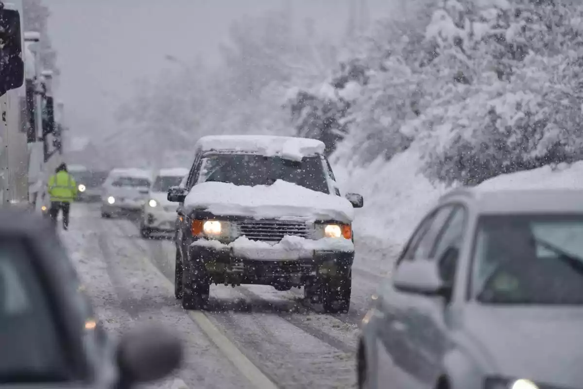 Vehicles circulen per una carretera nevada