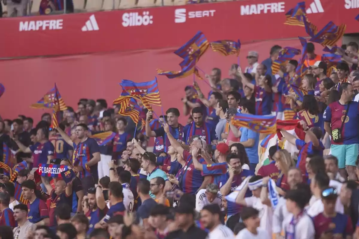Aficionados en un estadio animando con banderas y bufandas del FC Barcelona. Aficionados en un estadio animando con banderas y bufandas del FC Barcelona.