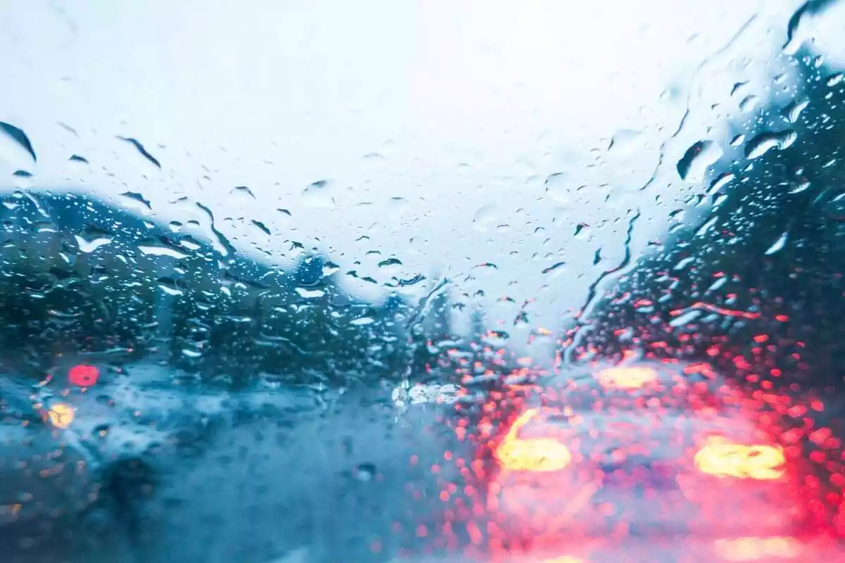 Vidre d'un cotxe amb gotes de pluja