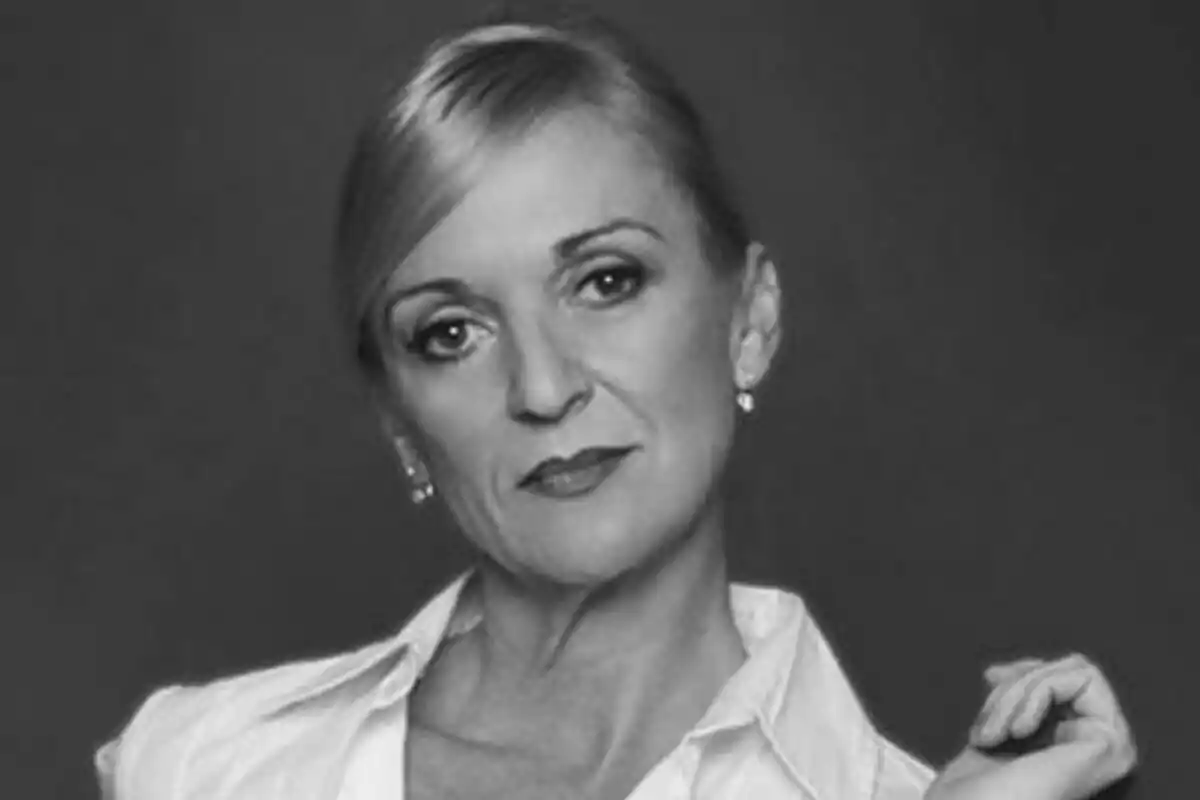 Cristina Fenollar de cabell ros recollit amb expressió seriosa portant una camisa blanca en una fotografia en blanc i negre