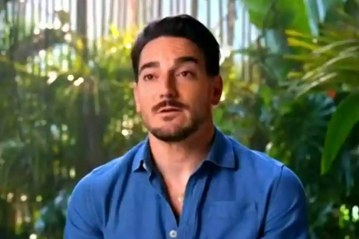 Damián Quintero amb barba i camisa blava està parlant davant d'un fons de vegetació a Supervivientes. Damián Quintero amb barba i camisa blava està parlant davant d'un fons de vegetació a Supervivientes.