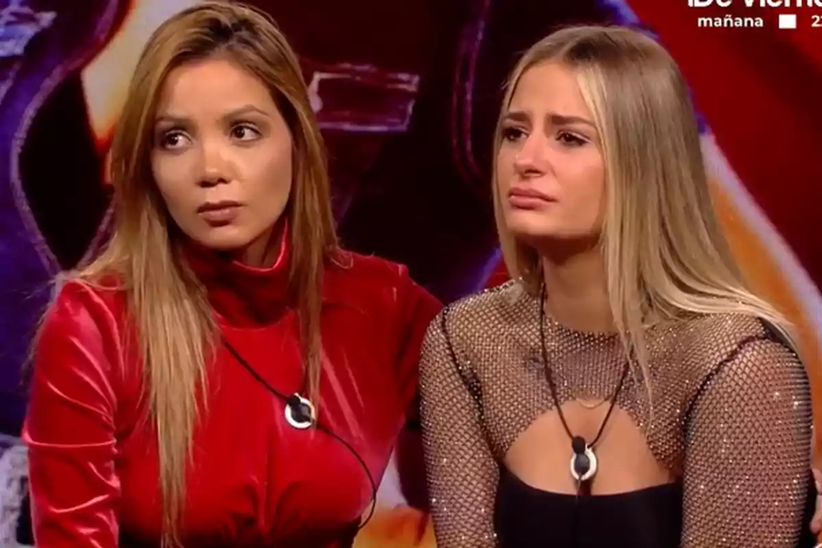 Daniela i Laura Galera assegudes a Gran Hermano, una amb un vestit vermell i l'altra amb un top de malla, totes dues amb expressions serioses.