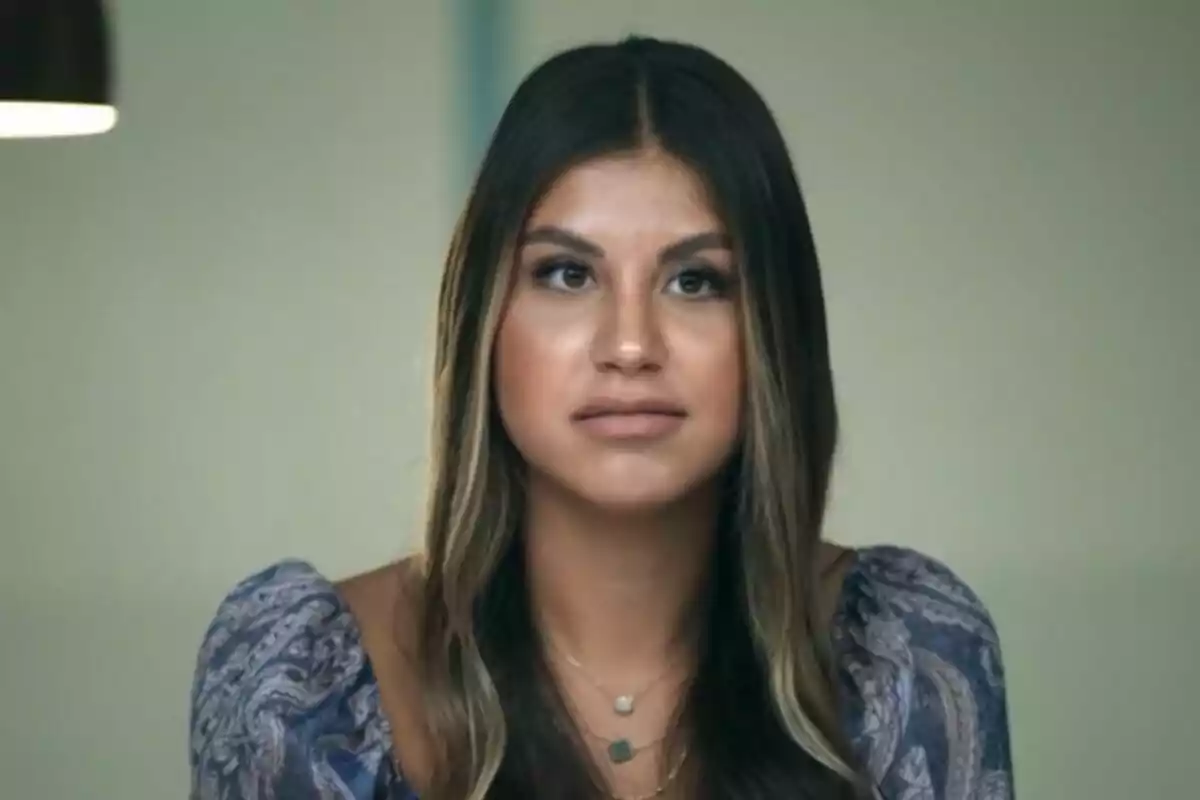 Daniela Sánchez, hija de Joaquín Sánchez, con cabello largo y oscuro, vistiendo una blusa con estampado, mirando al frente con expresión neutral.