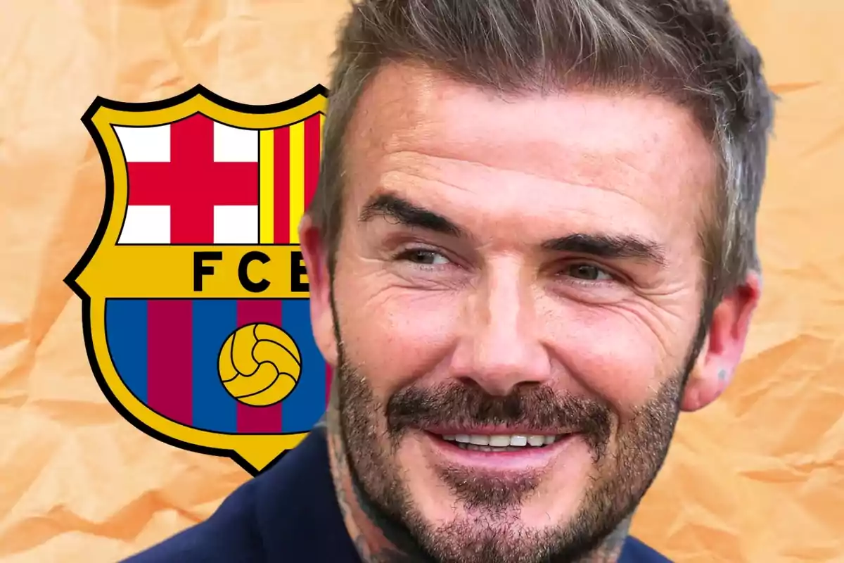 Un home somrient amb barba i cabells curts davant de l'escut del FC Barcelona.