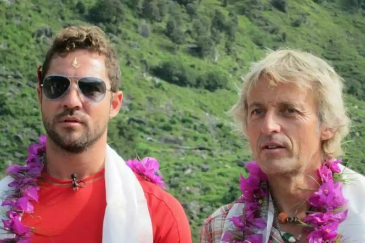 David Bisbal i Jesús Calleja amb collarets de flors i roba casual posen a l'aire lliure amb un fons de vegetació a Universo Calleja.