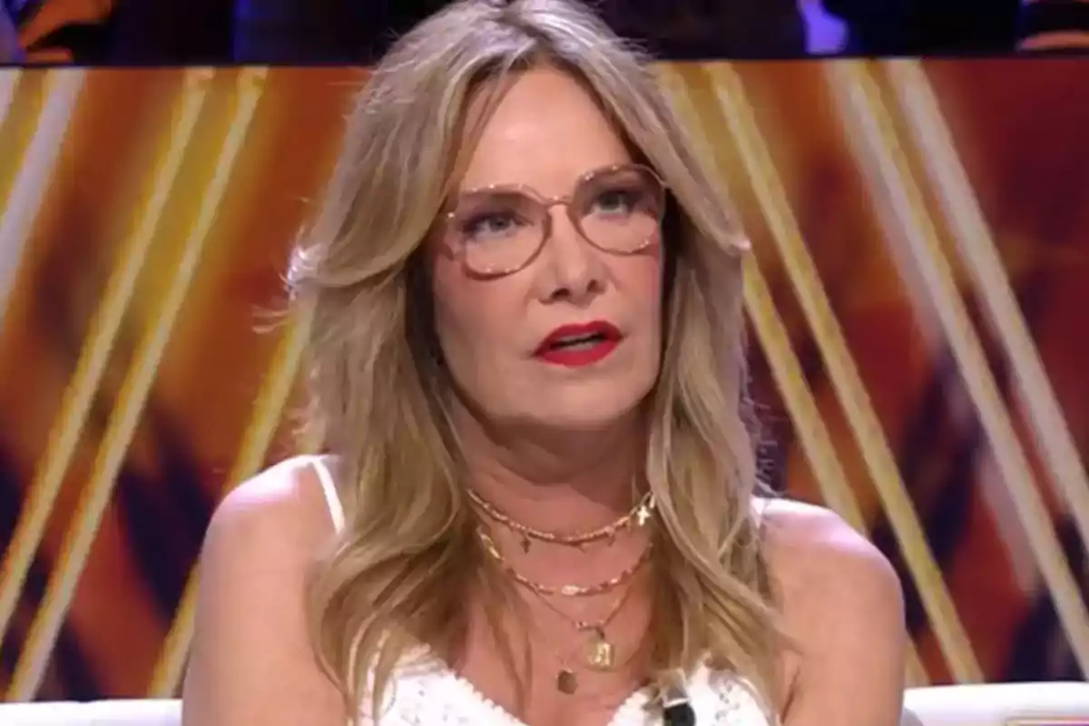 Belén Rodríguez està asseguda en un plató de televisió amb un fons de colors càlids.