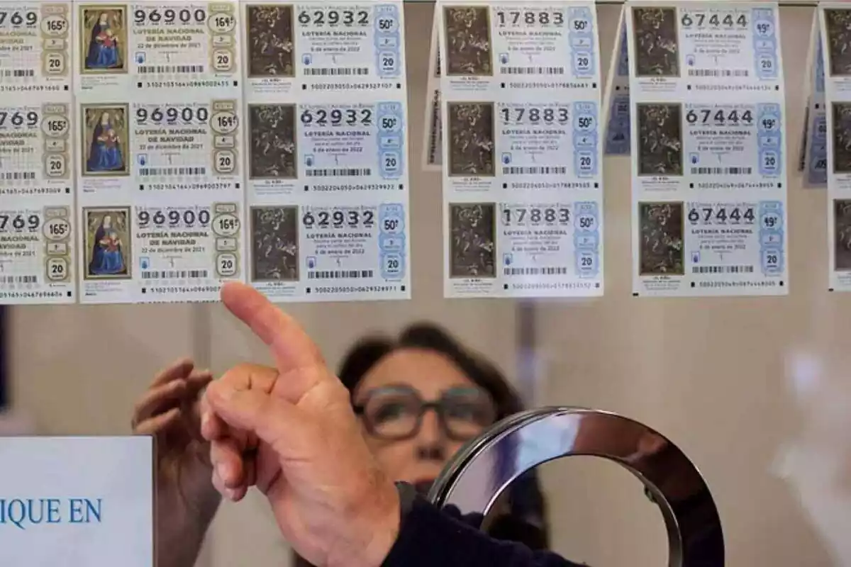 La mà d'un home assenyalant un dècim de la Loteria de Nadal