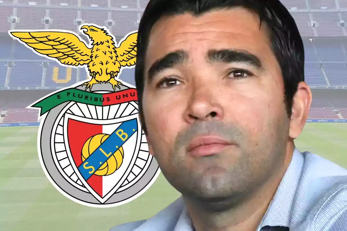 Un hombre con una expresión seria está frente al escudo del club de fútbol S.L. Benfica en un estadio vacío.