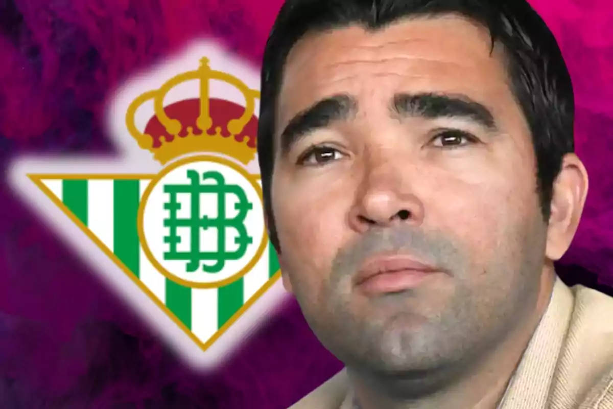 Un hombre con expresión seria frente al logo del Real Betis.