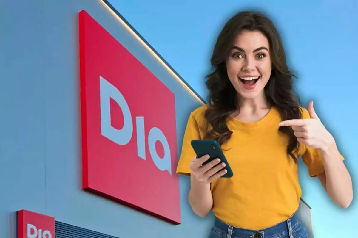 Mujer sonriente con camiseta amarilla sosteniendo un teléfono móvil frente a un cartel rojo de supermercado.