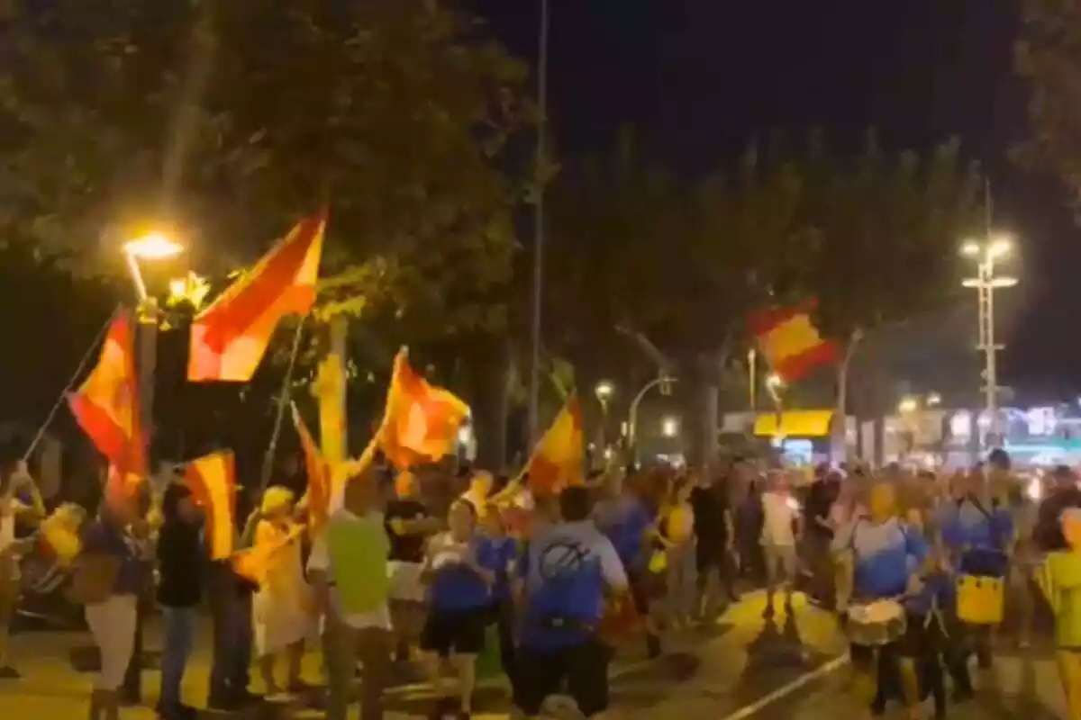 Captura de pantalla del vídeo en què es veuen desenes de manifestants amb banderes espanyoles envoltant una marxa de torxes independentistes