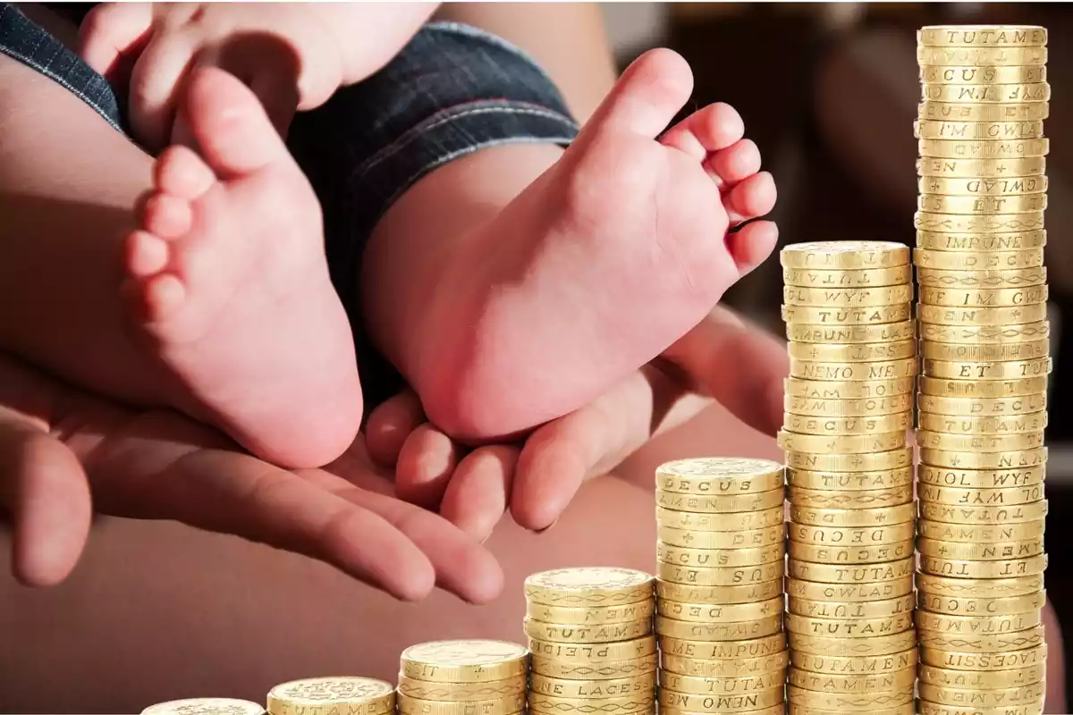 Els peus d'un nadó amb una muntanya de monedes en primer pla