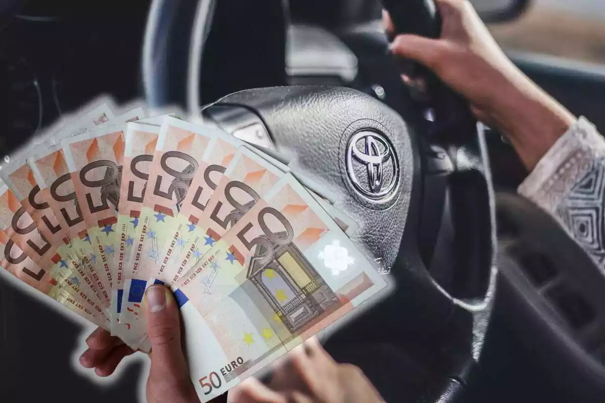 Una mà subjectant diversos bitllets de 50 euros i de fons una persona amb volant d'un cotxe