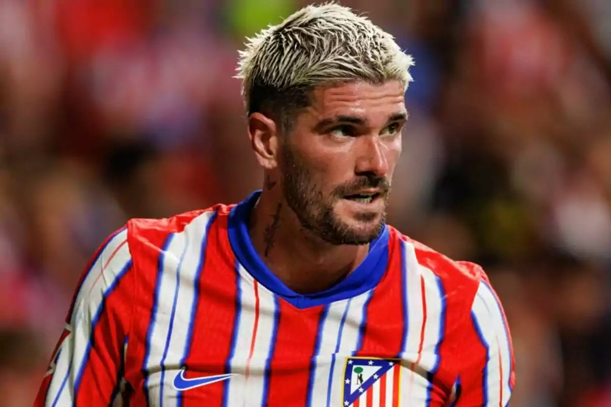 Un jugador de futbol amb cabell ros i barba vesteix una samarreta de ratlles vermelles i blanques amb detalls blaus. Un jugador de futbol amb cabell ros i barba vesteix una samarreta de ratlles vermelles i blanques amb detalls blaus.