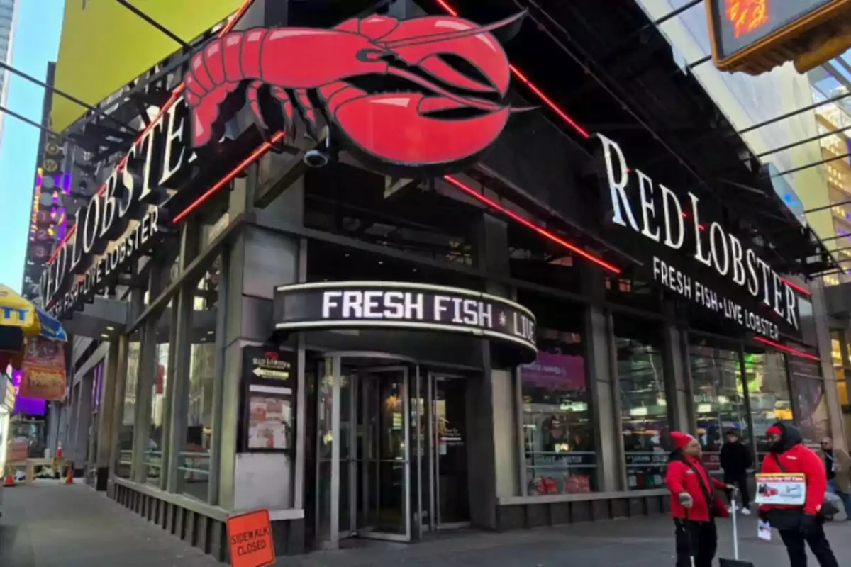 Façana d'un restaurant Red Lobster amb un gran rètol de llagosta vermella i persones caminant per la vorera. Façana d'un restaurant Red Lobster amb un gran rètol de llagosta vermella i persones caminant per la vorera.