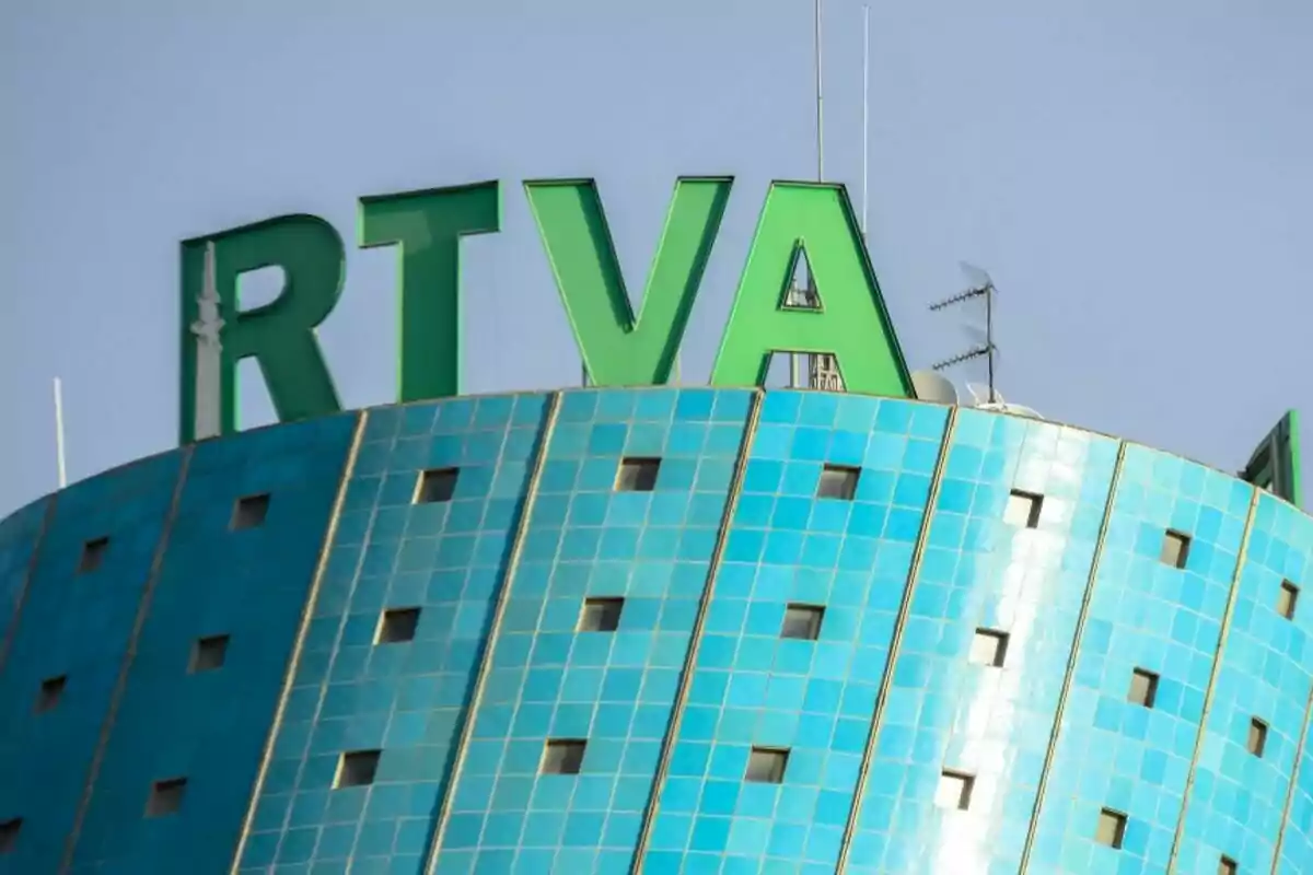 Edificio cilíndrico con fachada azul y letras verdes grandes de RTVE (Radio Televisión de Andalucía) en la parte superior.