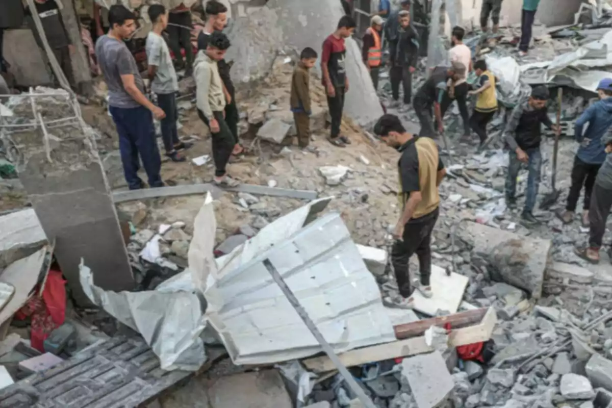 Diverses persones observen i caminen entre les runes d’un edifici destruït Diverses persones observen i caminen entre les runes d’un edifici destruït