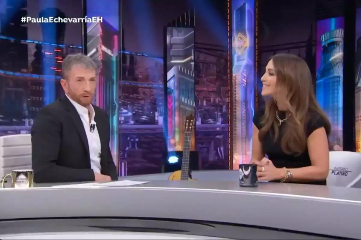 Pablo Motos i Paula Echevarría conversen a 'El Hormiguero' amb una guitarra de fons i una tassa sobre la taula.