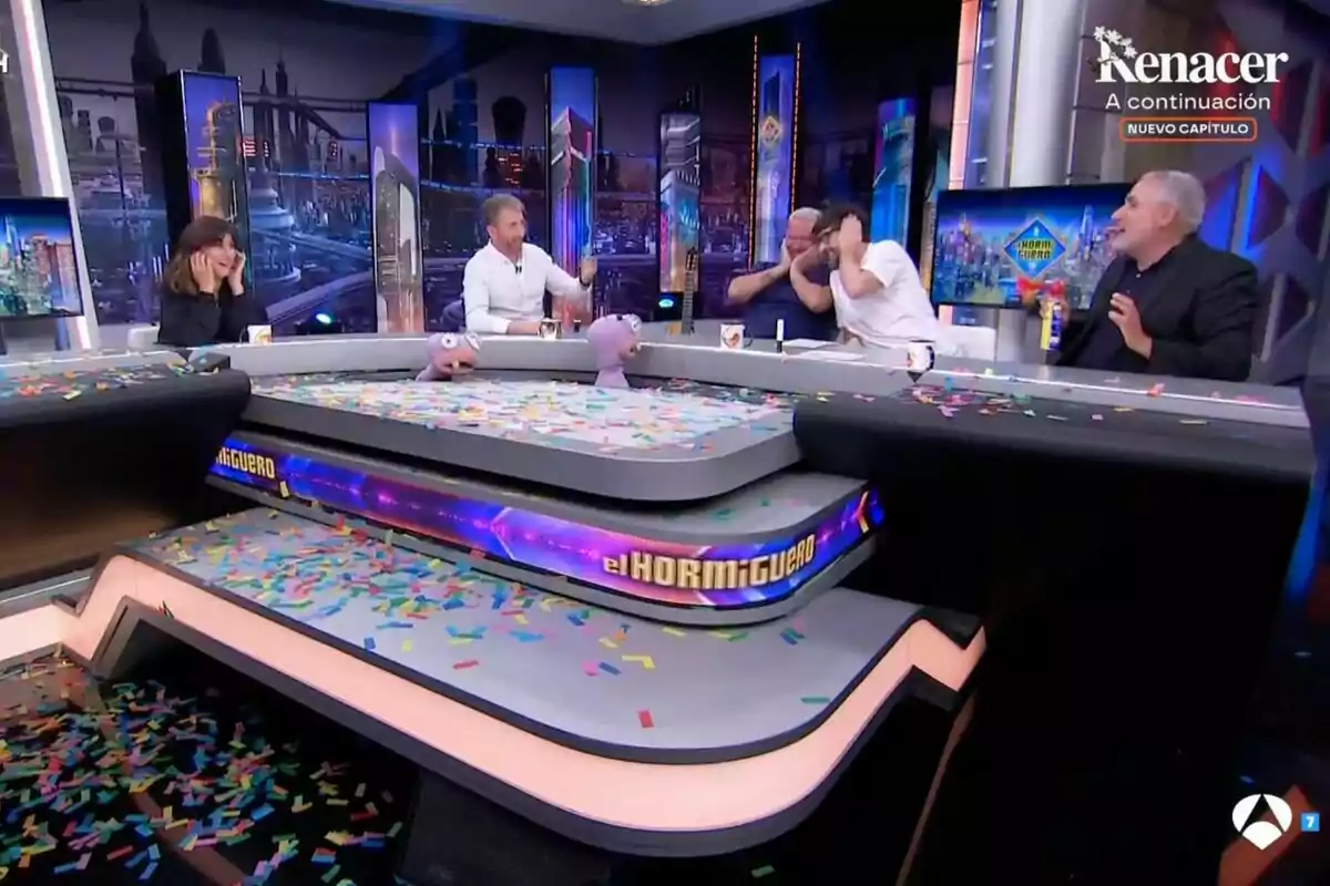 Persones assegudes al voltant d’una taula d’‘El Hormiguero’ coberta de confeti, amb titelles i ambient festiu Persones assegudes al voltant d’una taula d’‘El Hormiguero’ coberta de confeti, amb titelles i ambient festiu