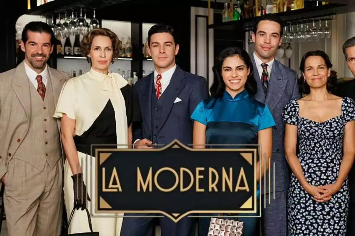 Un grup de persones format per Miguel Ángel Muñoz, Jesús Mosquera, Pepe Nufrio o Lola Marceli, elegantment vestides posant davant d'un bar amb el logotip de "La Moderna" en primer pla.