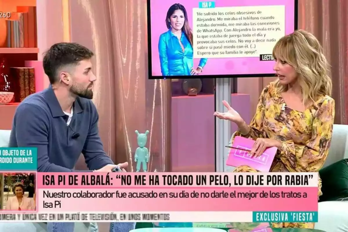 Alejandro Albalá i Emma García conversen al plató de Fiesta, amb una pantalla al darrere que mostra una imatge i text relacionat amb un tema de discussió.